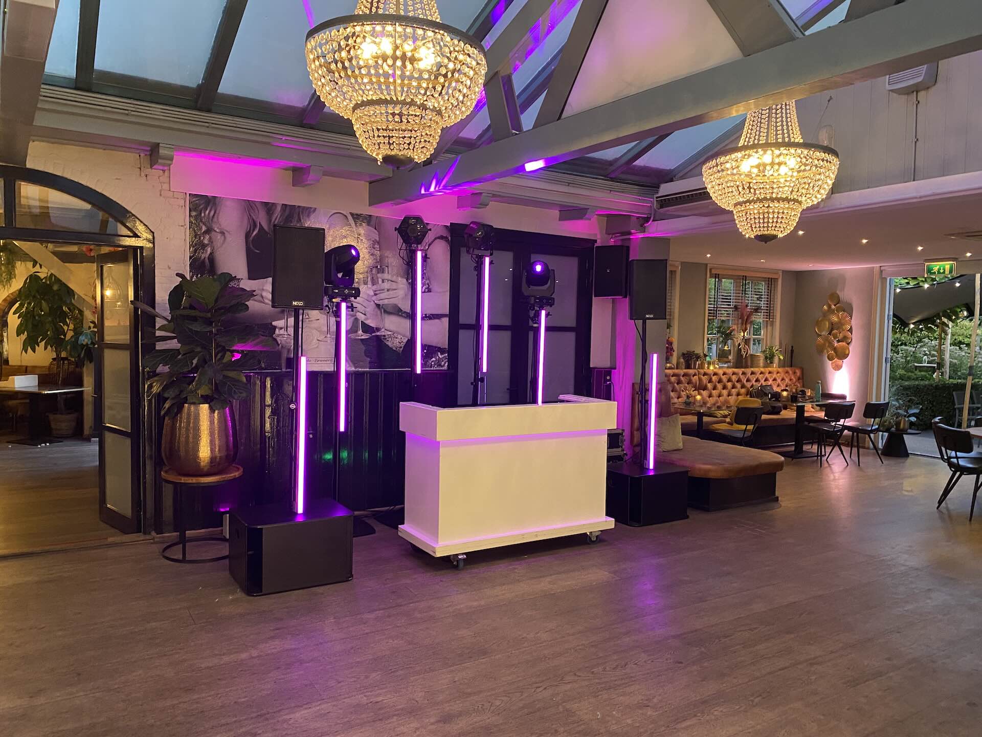 Complete drive-in show: witte DJ-booth met verlichte statieven, bewegende spots en geluid